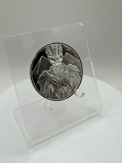 Futuristic alien silver coin with pyramid background artwork